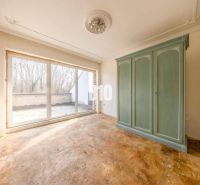 Ein Interieur eines Zimmers in einem Einfamilienhaus mit einem großen grünen Kleiderschrank und Glastüren.