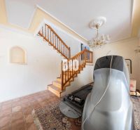 Interieur eines Einfamilienhauses mit Treppe, Kronleuchter, Boden und Sportgerät.
