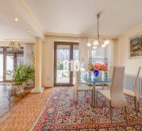 Esstisch in einem Einfamilienhaus mit Teppichen und Blumen auf dem Tisch.