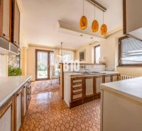 Küche in einem Einfamilienhaus mit Esszimmer, Fenstern und Zugang zum Garten.