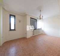 Wohnzimmer in einem Einfamilienhaus mit Kronleuchter und Boden in Holzoptik.