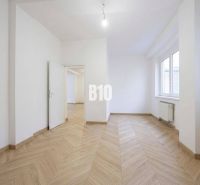 Ein Zimmer mit weißen Wänden und einem Boden in Holzoptik in einer 3-Zimmer-Wohnung.