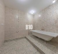 Ein Badezimmer in einer 3-Zimmer-Wohnung mit einer Badewanne und dekorativen Fliesen.