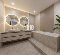 Elegantes Badezimmer mit Badewanne, Doppelwaschbecken und großen Spiegeln in einer 3-Zimmer-Wohnung.
