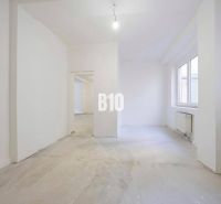 Interieur einer leeren 3-Zimmer-Wohnung mit weißen Wänden und einem großen Fenster.