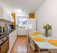 Küche in einer 2-Zimmer-Wohnung mit Esstisch und weißer Küchenzeile.