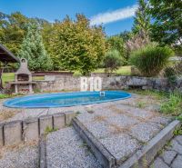 Der Garten eines Einfamilienhauses in Marianka mit Grill und Pool, umgeben von Grün.