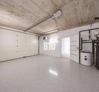Garage in einem Einfamilienhaus mit Tor und Kessel, ohne Holzdekor auf dem Boden.