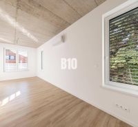 Ein Zimmer in einem Einfamilienhaus mit einem Boden in Holzoptik und weißen Wänden.