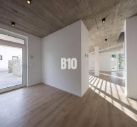 Innenraum eines Einfamilienhauses mit Betondecke und Boden in Holzoptik.
