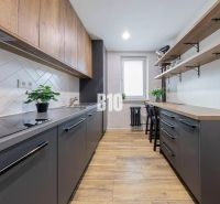 Küche in einer 3-Zimmer-Wohnung mit einem Boden in Holzoptik und einfachen Stauraumlösungen.