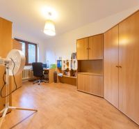 Ein Zimmer in einem Einfamilienhaus mit Holzmöbeln und einem Boden in Holzoptik.