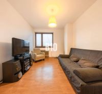 Wohnzimmer in einem Einfamilienhaus mit Sofa, Fernseher und Holzboden.