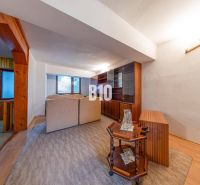 Wohnzimmer in einem Einfamilienhaus mit Perspektive auf Holzmöbel und bequeme Sitzgarnituren.