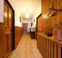 Ein Flur in einem Einfamilienhaus mit Holzverkleidung und Tongefäßen zur Dekoration.