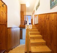 Holztreppe und Wandverkleidung in einem Einfamilienhaus mit einem Boden in Holzoptik.