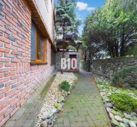 Ein Einfamilienhaus in Štvrtok na Ostrove mit Ziegelverkleidung und einem Steinweg im Garten.