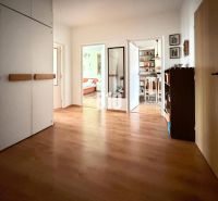 Der Flur einer 3-Zimmer-Wohnung mit Holzboden und Einbauschränken.
