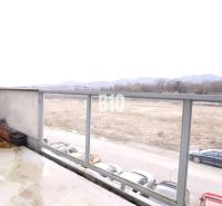 Blick auf die Umgebung von der Terrasse einer 2-Zimmer-Wohnung in Martin, Parkplatz und Feld am Horizont.
