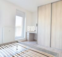 Schlafzimmer mit Holzboden in einer Zweizimmerwohnung, Kleiderschrank und Schreibtisch.