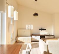 Innenraum einer 2-Zimmer-Wohnung mit Holzboden, hellen Wänden und großen Fenstern.