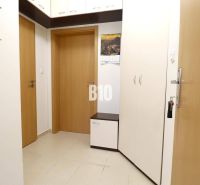 Eingangsbereich in einer 2-Zimmer-Wohnung mit weißen Möbeln und beigefarbenen Fliesen.