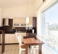 Küche in einer 2-Zimmer-Wohnung mit großem Fenster und Holzboden.