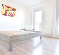 Helles Zimmer mit einem Bett auf dem Boden mit Holzdekor in einer 2-Zimmer-Wohnung.