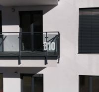 Balkon mit verglästem Geländer und Fensterläden an einem Gebäude einer Zweizimmerwohnung in Dolný Kubín.