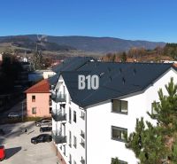 Neubau eines Wohnhauses in Dolný Kubín, mit Blick auf die Berge und einem Parkplatz.