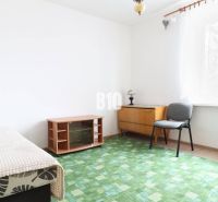 Innenraum einer 3-Zimmer-Wohnung mit Teppichboden, Sessel und Lampe am Fenster.