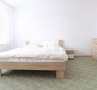 Schlafzimmer in einer 3-Zimmer-Wohnung mit Doppelbett, weißen Möbeln und Teppich.