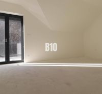 Helles Zimmer in einer 3-Zimmer-Wohnung mit großen verglasten Türen.