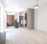 Innenraum einer 2-Zimmer-Wohnung mit Holzboden und Marmorverkleidung.