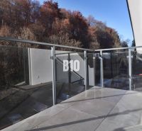 Balkon einer 2-Zimmer-Wohnung in Dolný Kubín mit Glasgeländer und von Bäumen umgeben.