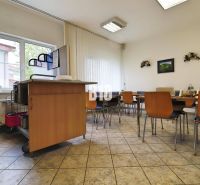 Kantine in Produktionsräumen mit Holzstühlen und Waschbecken.