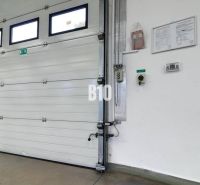 Industrielles Tor in Produktionsräumen mit Sicherheitsanweisungen an der Wand.