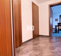 Flur mit Fliesen und Türen, die in ein Zimmer in einer 3-Zimmer-Wohnung führen.