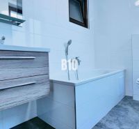 Badezimmer in einer 3-Zimmer-Wohnung mit Badewanne, Waschbecken, WC und einem Boden in Holzoptik.