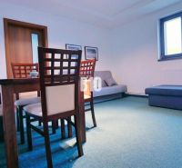 Esszimmer in einer 3-Zimmer-Wohnung mit Holzmöbeln und blauem Bodenbelag.