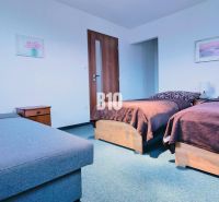 Schlafzimmer in einer 3-Zimmer-Wohnung mit zwei Betten, Nachttischen und einem Sofa.