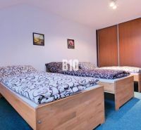 Schlafzimmer in einer 3-Zimmer-Wohnung mit drei Betten und Einbauschränken.