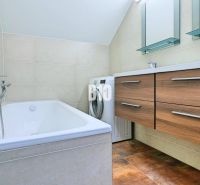 Badezimmer mit Dusche, Doppelwaschbecken, Waschmaschine und Schrank in einer 3-Zimmer-Wohnung.