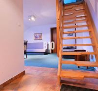 Eine Holztreppe in einer 3-Zimmer-Wohnung mit einem Boden in Holzoptik.