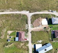 Luftaufnahme von Grundstücken - Wohnen in Necpaly mit sichtbaren Neubauten von Häusern.