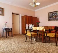 Wohnzimmer in einem Einfamilienhaus, Teppiche, Möbel aus dunklem Holz, Bilder an den Wänden.
