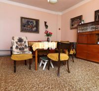 Esszimmer in einem Einfamilienhaus mit Holzmöbeln, gelbe Sessel, Teppiche.