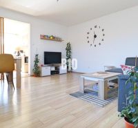 Wohnzimmer in einem Einfamilienhaus mit Holzboden, Esstisch und Sofa.