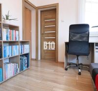 Bibliothek, Schreibtisch und Sessel in einem Einfamilienhaus mit Holzboden.