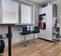 Küche mit Barhockern und Holzboden in einer 3-Zimmer-Wohnung.